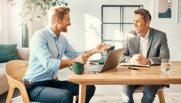 Two professionals discussing work across an office table