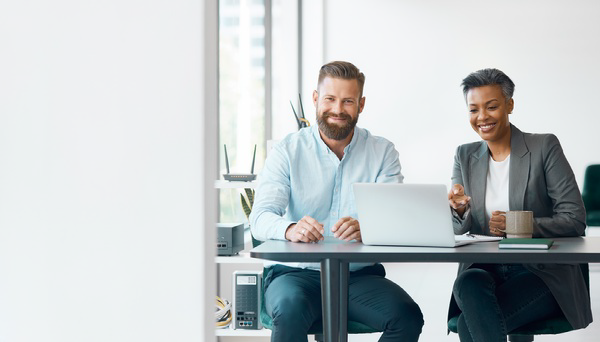 Two business professionals reviewing a laptop together