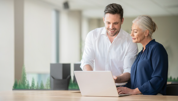 Two colleagues reviewing a laptop together